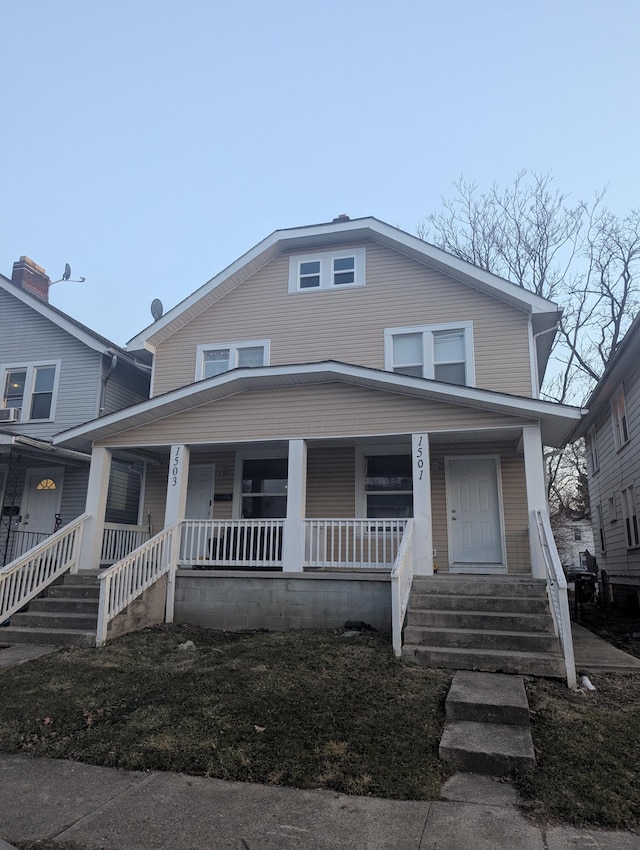 american foursquare style home with covered porch