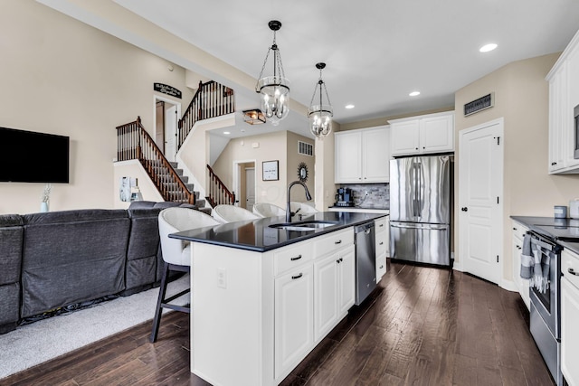 7179 Seymour Ct, Canal Winchester, OH 43110 - kitchen featuring stainless steel appliances, open floor plan, dark countertops, a kitchen breakfast bar, and recessed lighting