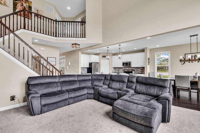 7179 Seymour Ct, Canal Winchester, OH 43110 - living area with stairs, a chandelier, recessed lighting, carpet flooring, and a towering ceiling