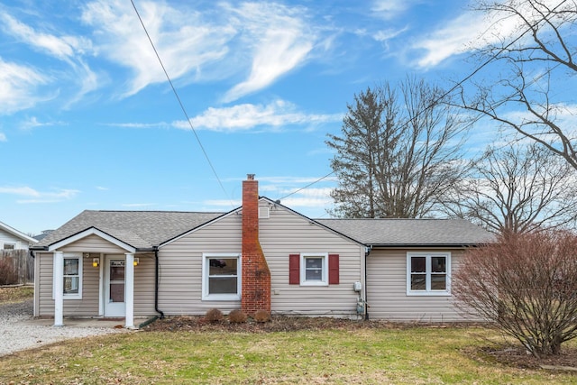 view of front of home featuring roof with shingles, a front lawn, a chimney, and fence