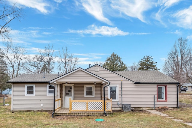 view of front of home featuring a shingled roof, fence, central air condition unit, a porch, and a front yard