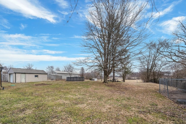 view of yard with an outbuilding, fence, and a swimming pool