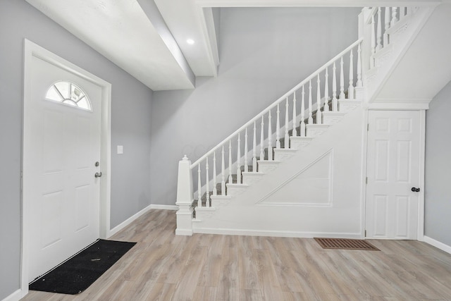 entryway with stairs, wood finished floors, and baseboards