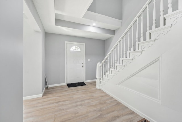 entryway featuring stairway, baseboards, and wood finished floors