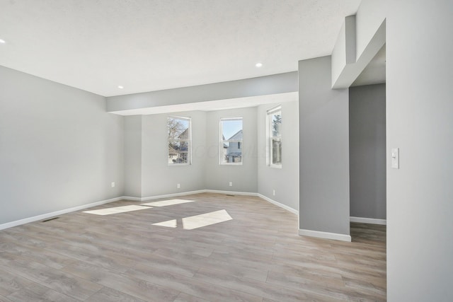 unfurnished room with light wood-style flooring, recessed lighting, visible vents, and baseboards