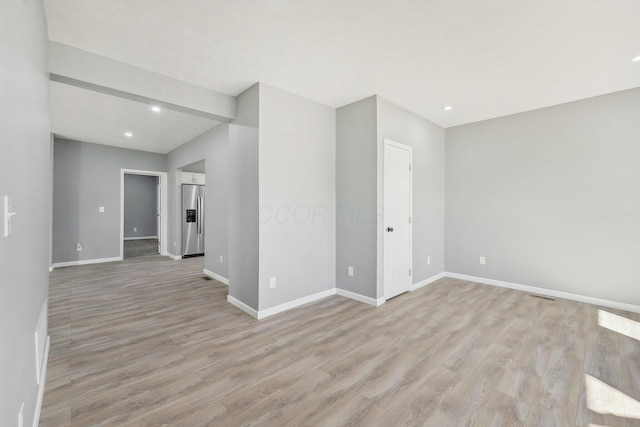 unfurnished room with recessed lighting, light wood-style flooring, and baseboards