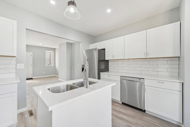 kitchen featuring a sink, stainless steel appliances, tasteful backsplash, and white cabinets