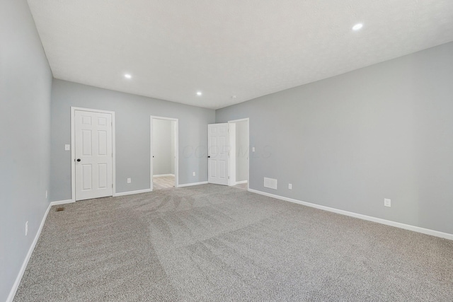 unfurnished bedroom featuring recessed lighting, visible vents, baseboards, and carpet flooring