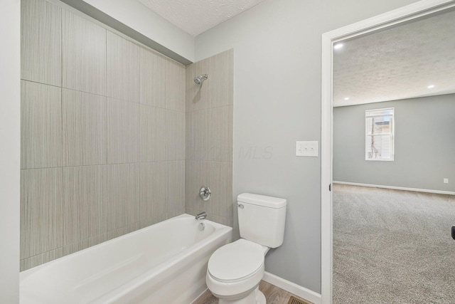 full bath featuring baseboards, toilet, shower / bathtub combination, and a textured ceiling