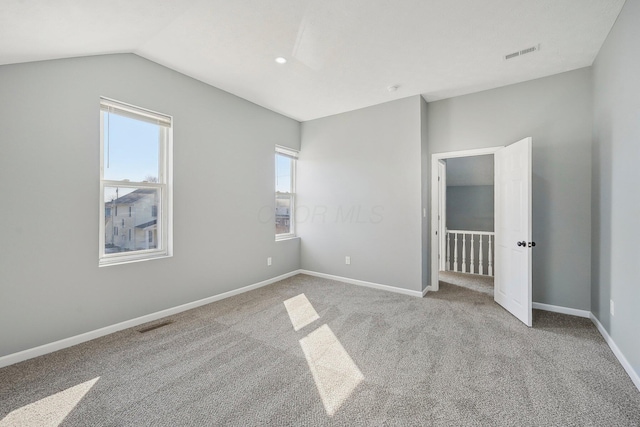 unfurnished bedroom with visible vents, baseboards, carpet floors, and vaulted ceiling