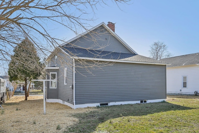 view of side of property featuring a yard and a chimney