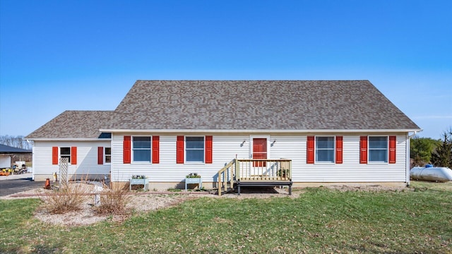 view of front facade featuring a front lawn and roof with shingles