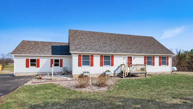 view of front of home featuring driveway, a front yard, and roof with shingles