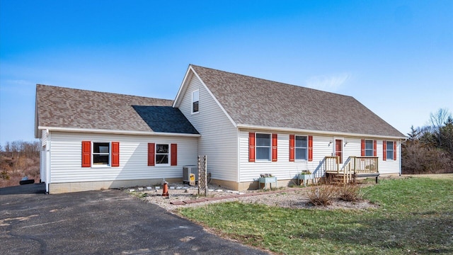 view of front of house with a front yard and a shingled roof