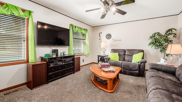 living area with visible vents, carpet floors, baseboards, and ceiling fan