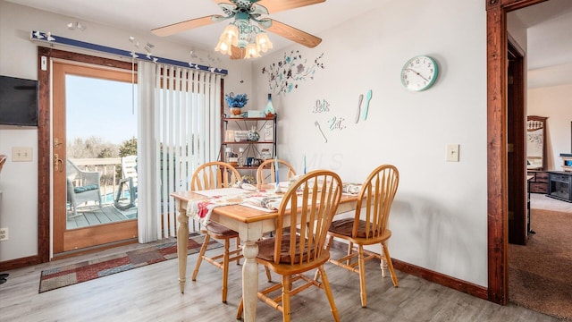 dining space with baseboards, wood finished floors, and ceiling fan