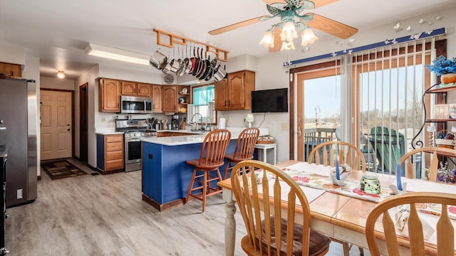 dining room featuring light wood-style flooring and a ceiling fan