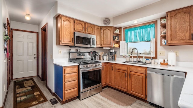 kitchen with open shelves, appliances with stainless steel finishes, light countertops, and a sink