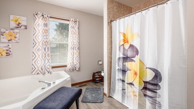 full bath featuring baseboards, a shower with curtain, wood finished floors, and a bath