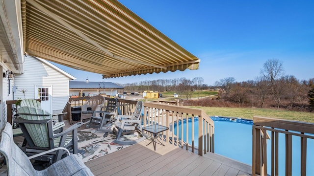 wooden terrace featuring a lawn and an outdoor pool