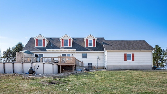 rear view of house with a shingled roof, a yard, an outdoor pool, and a wooden deck