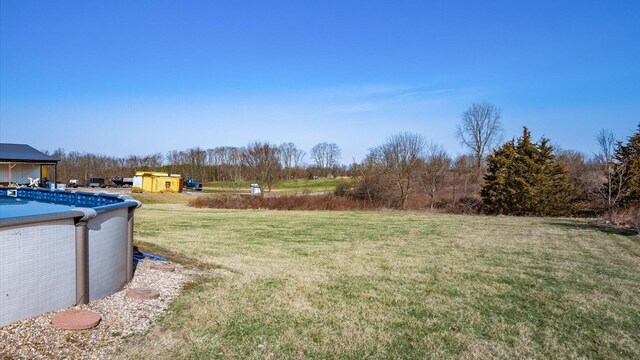 view of yard with an outdoor structure, a storage unit, and an outdoor pool