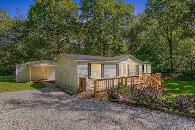 manufactured / mobile home featuring an outbuilding, a front lawn, and a deck