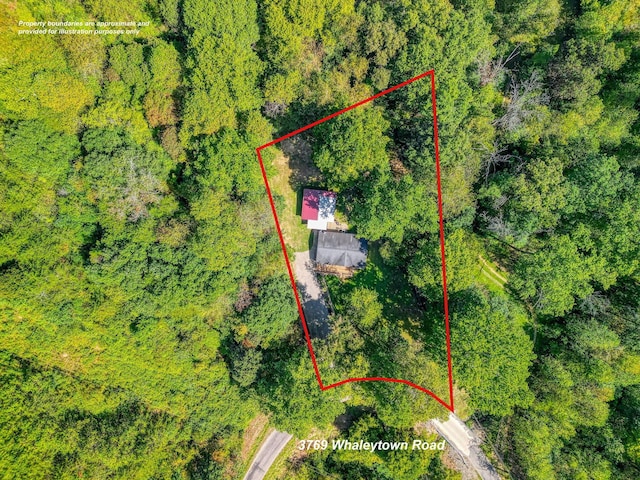 birds eye view of property featuring a wooded view