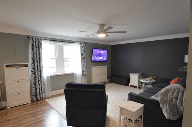 living area featuring a ceiling fan, wood finished floors, and ornamental molding