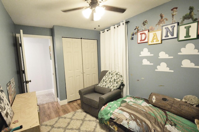 bedroom with a closet, ceiling fan, baseboards, and wood finished floors