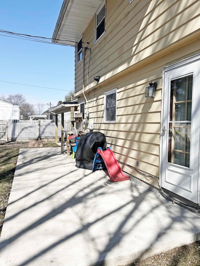 view of side of property with a patio area and fence