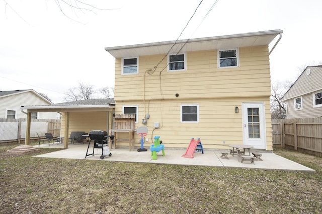 rear view of house featuring a yard, a fenced backyard, and a patio