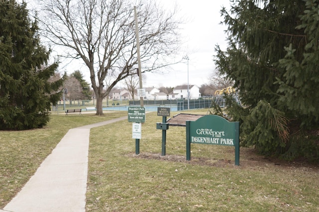 view of community featuring a yard, a residential view, and fence