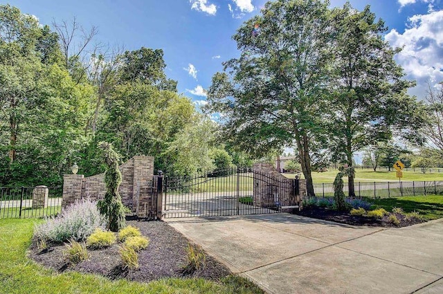 view of gate with fence and a yard