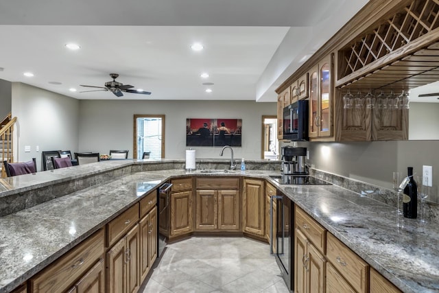 kitchen with recessed lighting, glass insert cabinets, black appliances, and a sink