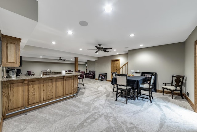 dining area featuring recessed lighting, a ceiling fan, light colored carpet, baseboards, and stairs
