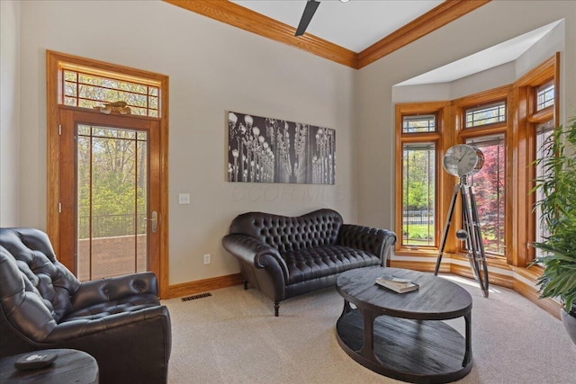 living room with plenty of natural light, crown molding, carpet flooring, and baseboards