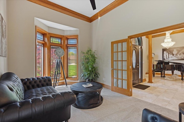 living room featuring ornamental molding, a towering ceiling, a notable chandelier, and baseboards