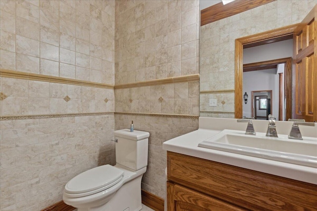 half bathroom with toilet, tile walls, and vanity