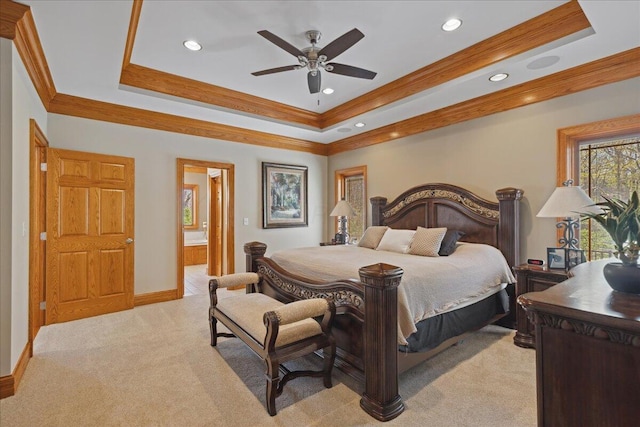 bedroom featuring recessed lighting, connected bathroom, a tray ceiling, ornamental molding, and light colored carpet