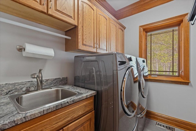 laundry area with visible vents, a sink, cabinet space, and independent washer and dryer