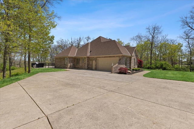 view of side of property with a garage, a shingled roof, a lawn, driveway, and brick siding
