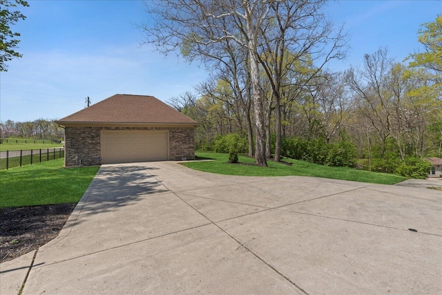 view of side of property with fence, a yard, a shingled roof, and concrete driveway