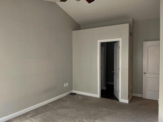 unfurnished bedroom with carpet, visible vents, vaulted ceiling, and baseboards