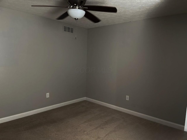 carpeted spare room with visible vents, ceiling fan, a textured ceiling, and baseboards