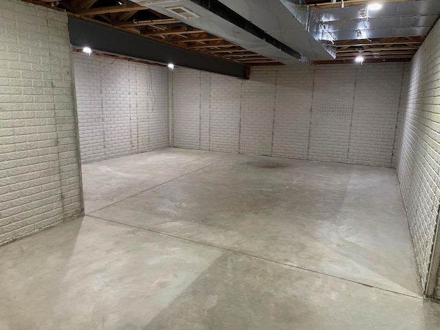 unfinished basement with brick wall and visible vents