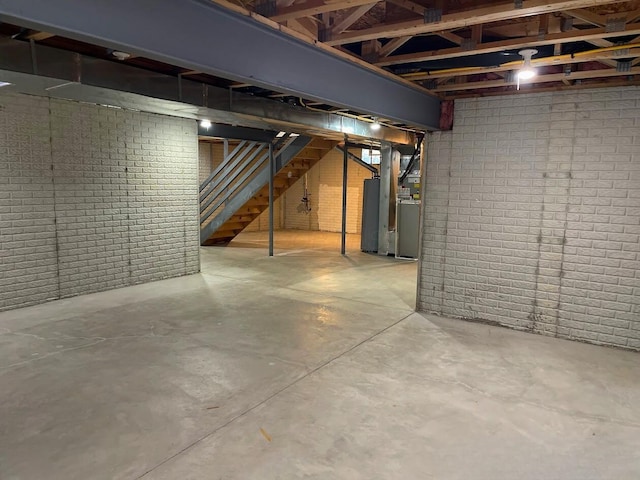 unfinished basement with brick wall and stairway