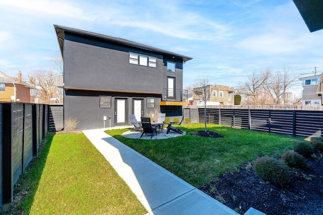 back of property featuring a fenced backyard, a lawn, a patio, and stucco siding