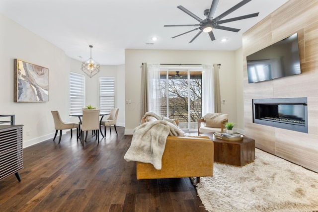 living room featuring recessed lighting, a tile fireplace, dark wood finished floors, and baseboards