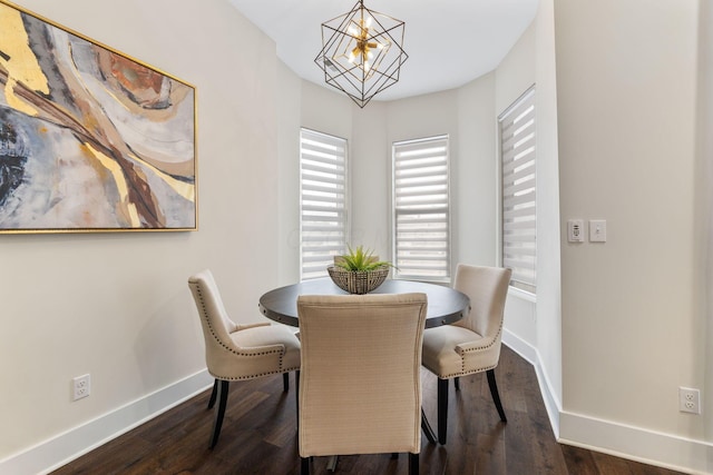 dining room featuring dark wood-style floors, an inviting chandelier, and baseboards